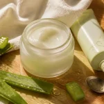 Crème aloe vera visage hydratante, pot en verre et feuilles d’aloe sur table